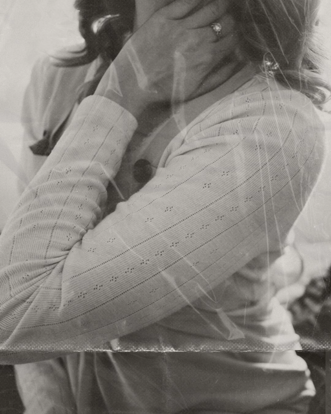 black and white photo of a woman, holding her neck