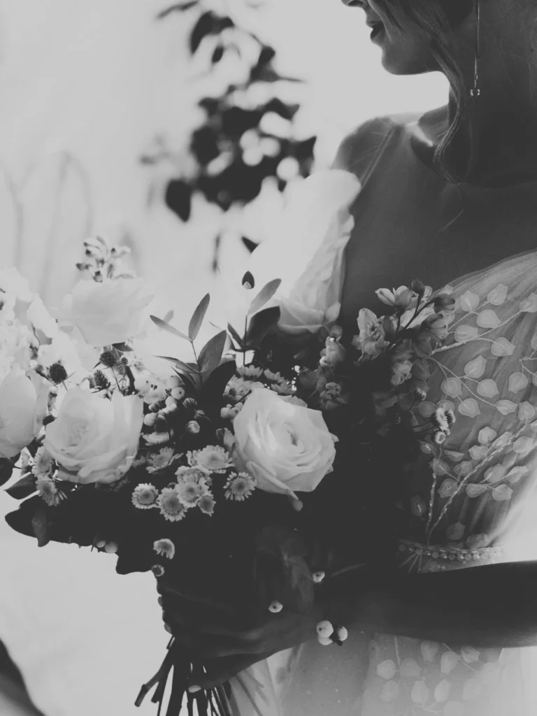 black and white image of bride holding flowers