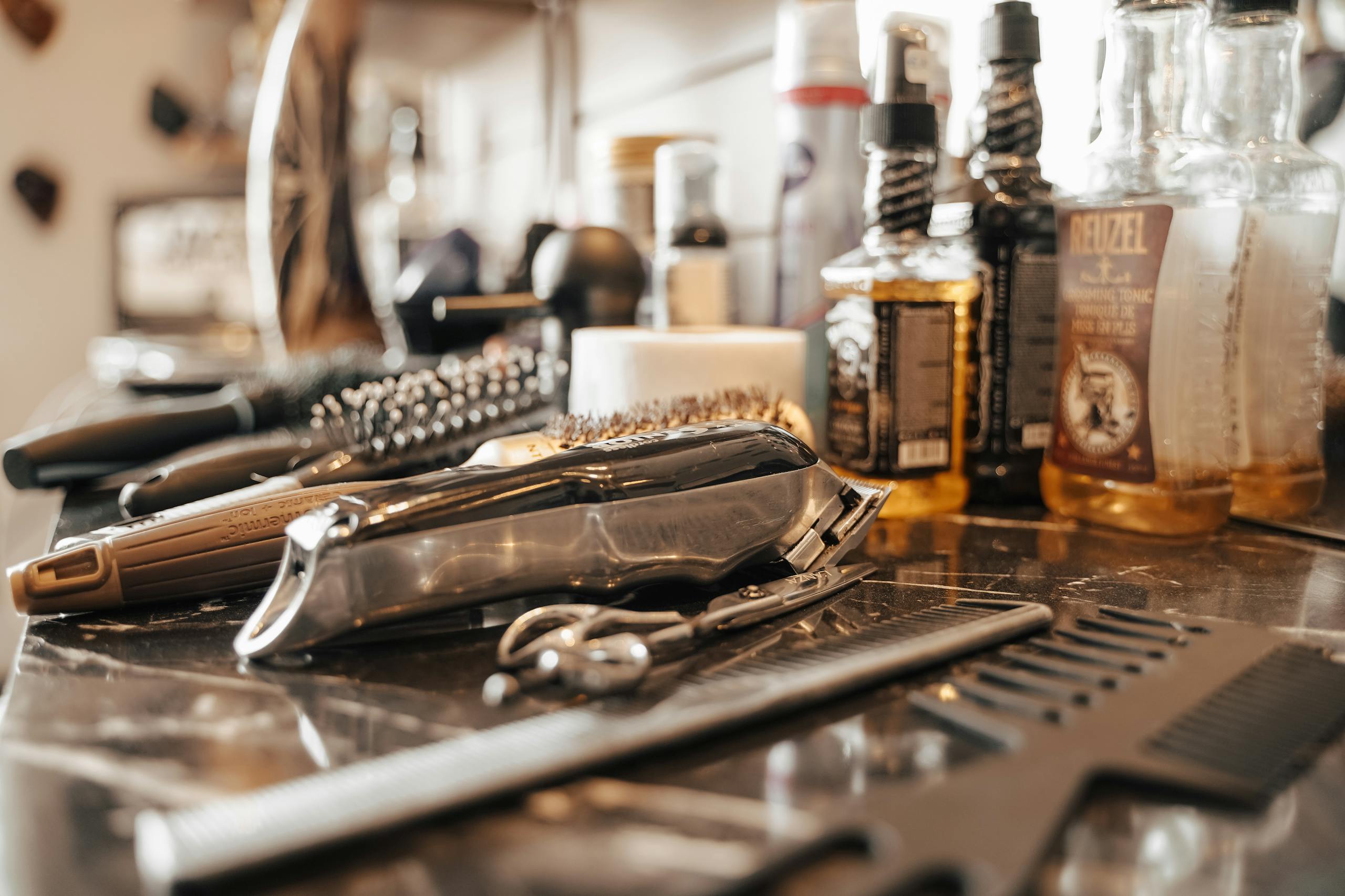 Close-up of barber tools and grooming products on a workstation in a barbershop, Belgium.