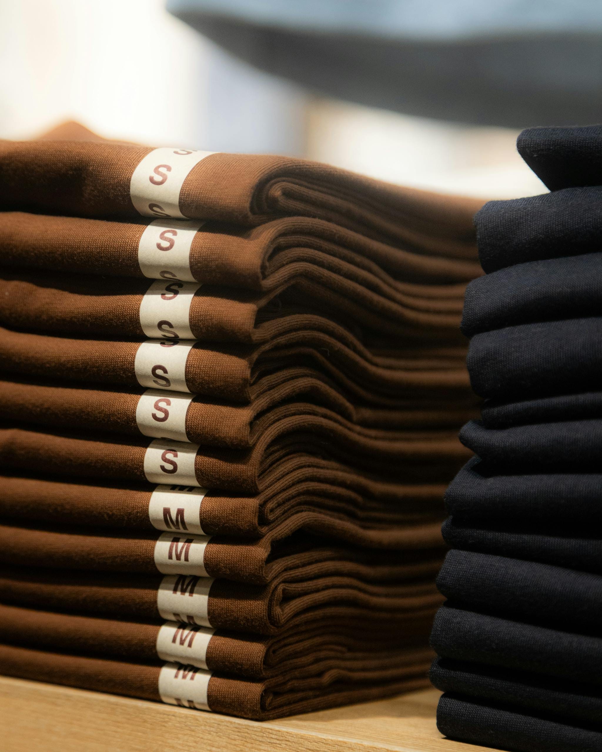 Neatly folded brown and black shirts in a retail store in Hà N?i, Vietnam.