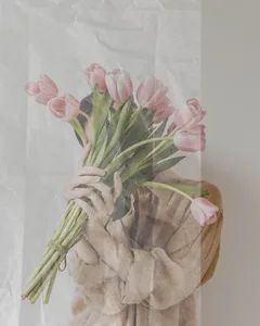 soft neutral image of woman holding pink tulips