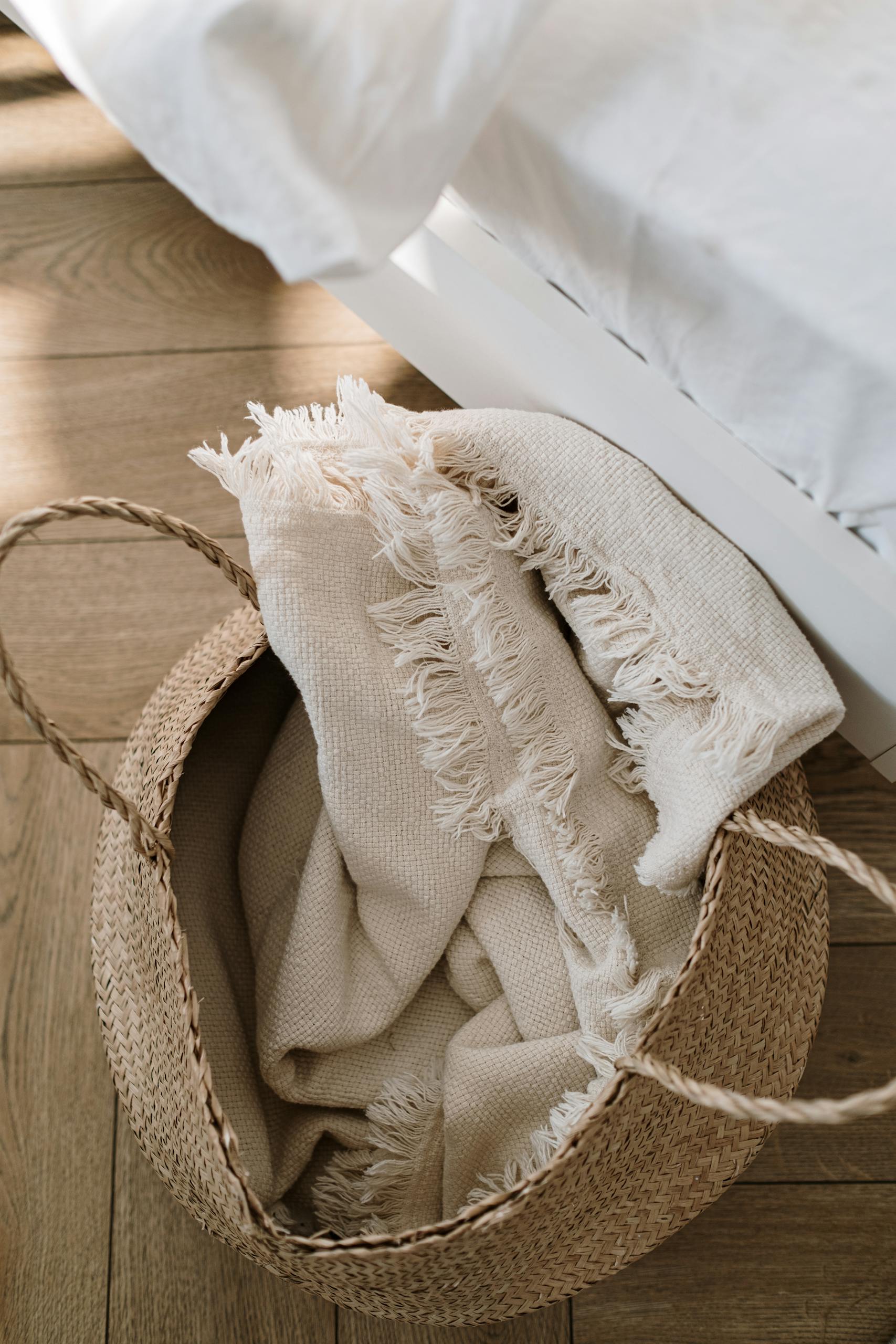 A wicker basket with a soft fringed white blanket adds warmth and texture to a modern bedroom.