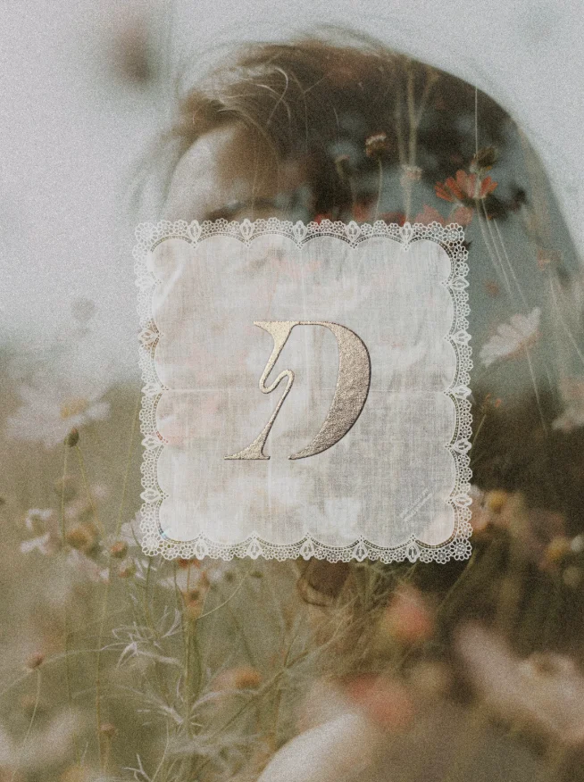 Wedding photo with a lace-framed gold monogram 'D' in the center.
