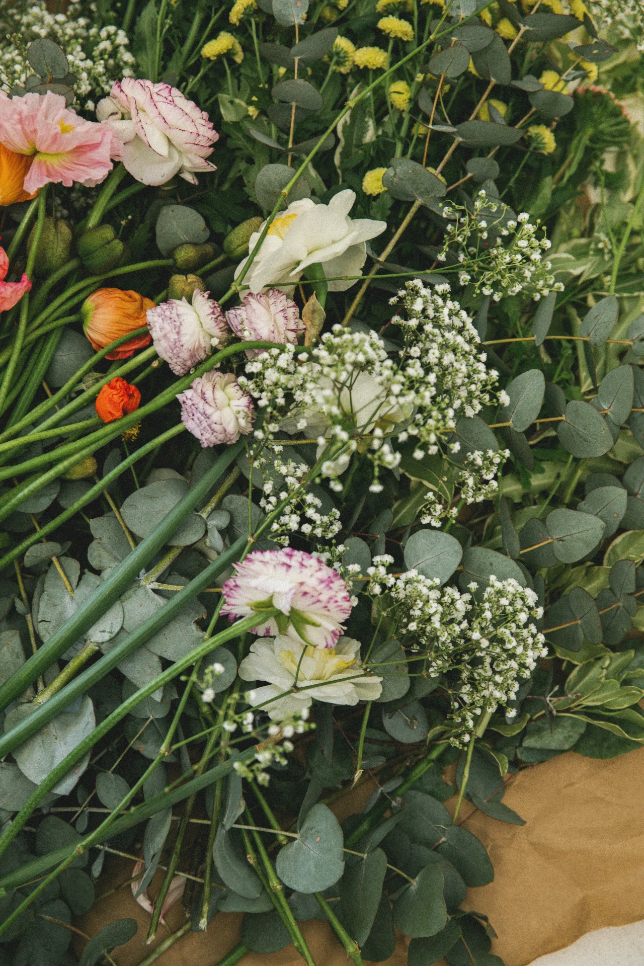 Maeve Wedding Floristry website design with terracotta background, hand-stamped yellow floral logo, handwritten Maeve wordmark, black and white couple photography, and a tulip photo, wedding florist branding by The Good Canvas